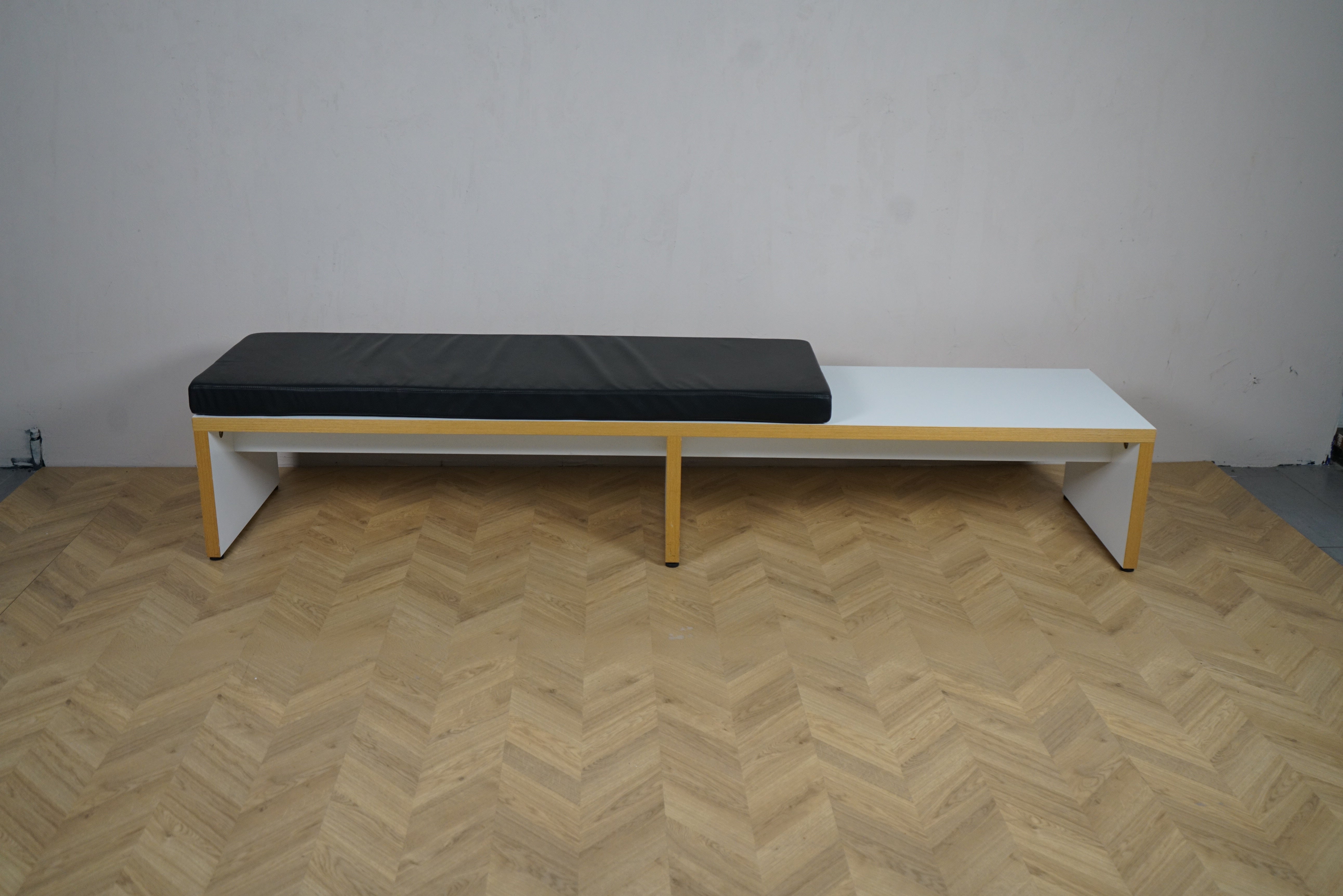 Frontbillede af moderne bænk med sort hynde, 255x60x43 cm – ideel til lounge, kontor og skolemiljø